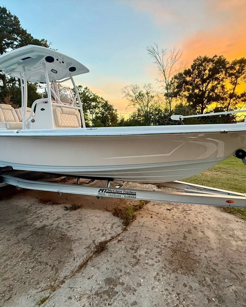 White bay boat with a T-top on its trailer at sunset after a marine detail