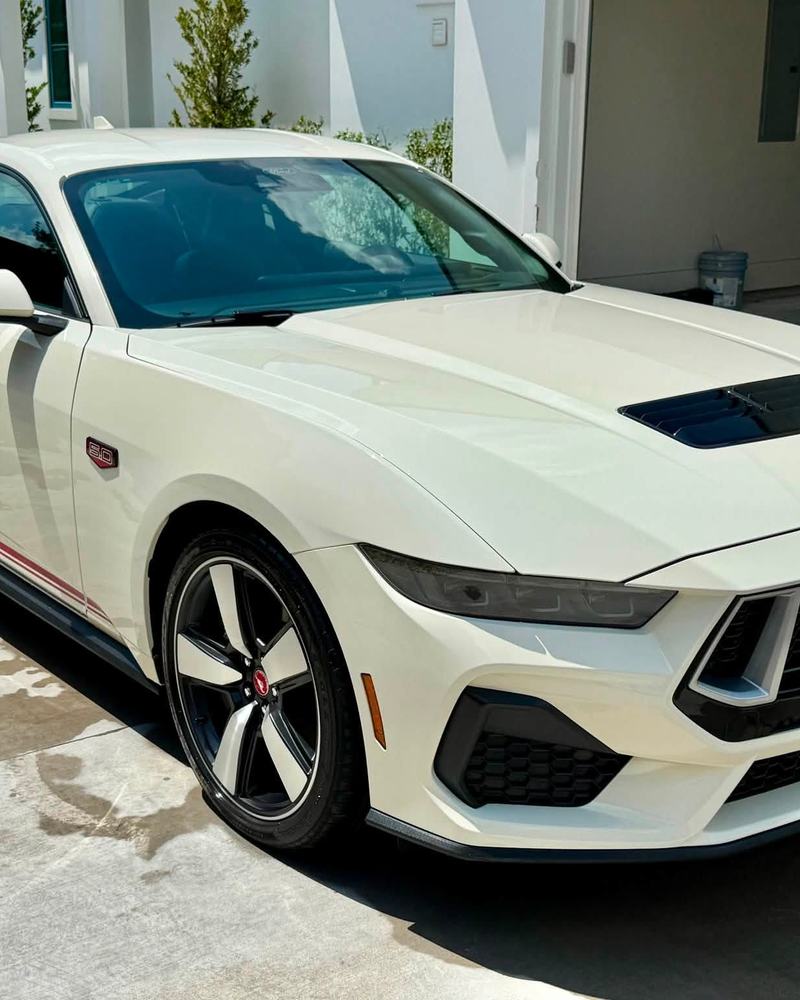White Ford Mustang GT in a garage bay after a detail, paint like glass