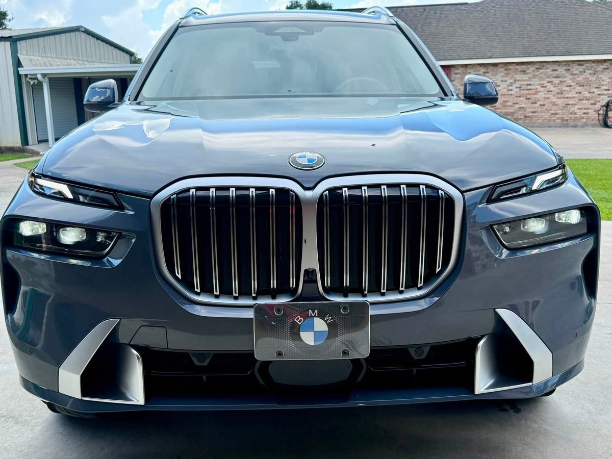 Blue-grey BMW X7 front end after a detail, grille and headlights gleaming